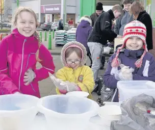  ??  ?? ●● Grace Podmore, Sarah Podmore and Emilia Podmore preparing to make bird food