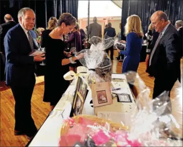  ?? BOB RAINES — DIGITAL FIRST MEDIA ?? Guests look at silent auction items during the Frederick Living 120th Star-Studded Event at the Sunnybrook Ballroom Oct. 7, 2016.