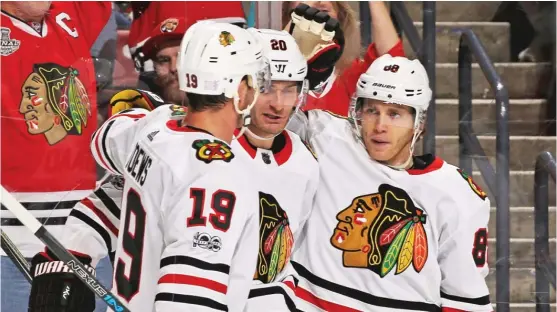  ?? | JOEL AUERBACH/ GETTY IMAGES ?? Patrick Kane ( right) celebrates his second- period goal with Jonathan Toews ( left) and Brandon Saad.