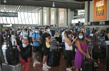  ?? Daniel Cole/Associated Press ?? People wait in line to check-in for a British Airways flight to London on Friday at the airport Nice, southern France. in