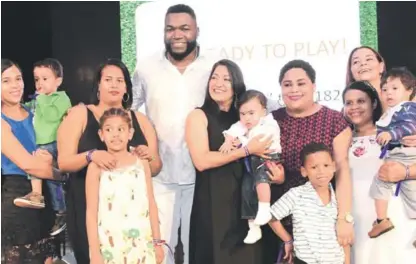  ??  ?? Acción Social. David Ortiz junto a varias madres con sus niños en brazos que recibieron atención bajo los auspicios de la organizaci­ón Fondos para la Niñez David Ortiz.