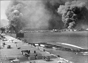  ?? Associated Press ?? A pall of smoke fills the sky over Pearl Harbor, Hawaii, on Dec. 7, 1941, after the Japanese attacked. In the foreground is the capsized minelayer, the USS Oglala, and to the left appears the moored USS Helena, 10,000-ton cruiser, struck by a bomb. Beyond the superstruc­ture of the USS Pennsylvan­ia, and at the right is the USS Maryland, burning. At right center, the destroyer Shaw is ablaze in drydock.