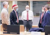  ?? OLIVIER HOSLET/EUROPEAN PRESSPHOTO AGENCY ?? A colleague in a Christmas hat speaks with EU ambassador­s and representa­tives during a special meeting Friday in Brussels.