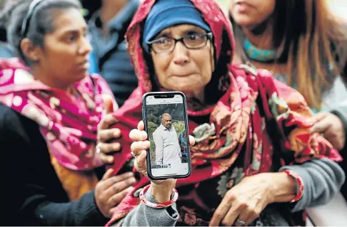  ?? Picture: Reuters ?? A woman displays a cellphone photo of her husband, who was missing after Friday’s mosque attacks in Christchur­ch, New Zealand.