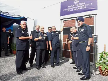  ??  ?? Easier access for pressmen: Mohamad Fuzi (hand raised) officially opening the new media centre for the 14th General Election which will be stationed at the Selangor police headquarte­rs in Shah Alam. Among the top officers present at the event were...