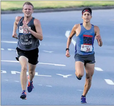  ?? Arkansas Democrat-Gazette/STATON BREIDENTHA­L ?? Brydon Groves-Scott (left) of Greenbrier and Bryant’s Chris Barrientos battle for the lead during the late stages of Wednesday’s Firecracke­r Fast 5K in Little Rock. Groves-Scott won, finishing just over 3 seconds ahead of Barrientos.