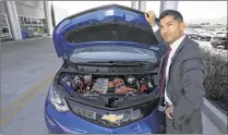  ?? BRIAN VAN DER BRUG / LOS ANGELES TIMES ?? Community Chevrolet’s Oscar Gutierrez shows a Bolt EV electric car in Burbank, Calif. Of some 250 vehicles the dealer sells a month, about a fifth are electric Volts and Bolts.