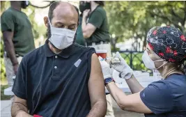  ?? PEDRO PORTAL pportal@miamiheral­d.com ?? Nurse Niurka Pérez vaccinates Uberne Vargas in downtown Miami on May 21.