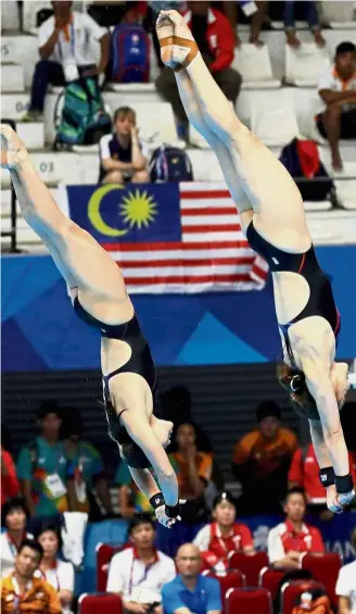  ??  ?? In sync: Leong Mun Yee and Nur Dhabitah Sabri in action for the women’s synchronis­ed 10m platform category at the Gelora Bung Karno Aquatic Center last night.