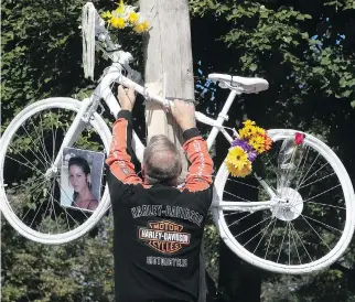  ?? PIERRE OBENDRAUF ?? Harold Desrochers, father of cyclist Valérie Bertrand Desrochers, puts up a ghost bike at the corner of St-Zotique and 19th Ave. on Sunday. Valerie died after a collision with a truck in June. This is the second ghost bike installed in her honour, after the first one disappeare­d in recent weeks.