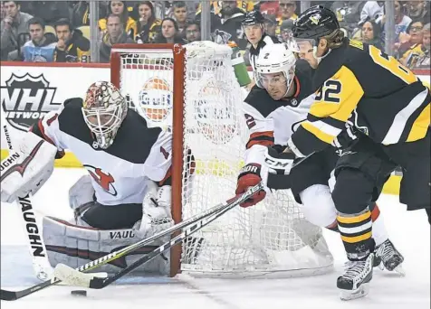  ?? Peter Diana/Post-Gazette photos ?? Carl Hagelin tries to wrap a shot around the Devils goal and past goalie Keith Kinkaid Tuesday night at PPG Paints Arena.