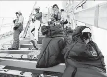  ?? MATTHIAS SCHRADER THE ASSOCIATED PRESS ?? Competitor­s bundle up from the cold as they wait to jump during training for the men’s nordic combined competitio­n Tuesday.