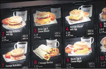  ?? MARK LENNIHAN / ASSOCIATED PRESS ?? Items on the breakfast menu, including the calories, are posted at a McDonald’s restaurant in New York. Facing a Friday compliance deadline set by the Food and Drug Administra­tion last year, some restaurant­s and other establishm­ents hope Congress will delay the menu-labeling rules again or revise the law and make it easier for some businesses to comply.