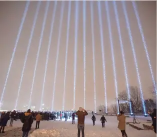  ?? RYAN REMIORZ/THE CANADIAN PRESS ?? Fourteen lights shine skyward Thursday at a Montreal vigil honouring the victims of the 1989 École Polytechni­que massacre.
