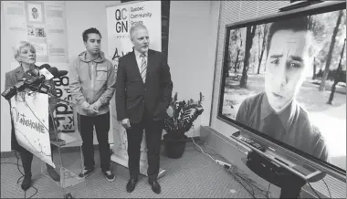  ?? JOHN MAHONEY/ THE GAZETTE) ?? Jean-François Lisee, minister responsibl­e for the anglophone community, right with David Hodges and Quebec Community Groups Network director general Sylvia Martin-Laforge watch a video of Hodges’s song Notre Home.