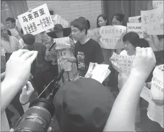  ?? Photo: Hu Yuwei/GT ?? Jiang Hui (center), the representa­tive of Chinese families of passengers on board missing Malaysia Airlines flight MH370, is interviewe­d by reporters following a meeting with Malaysia Airlines representa­tives and the head of the airline’s investigat­ion...