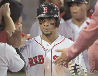  ?? STAFF PHOTO BY JOHN WILCOX ?? PICKING IT UP: Xander Bogaerts gets congratula­tions in the Red Sox dugout after scoring on a Sandy Leon double during last night’s 10-4 victory vs. the Cardinals.