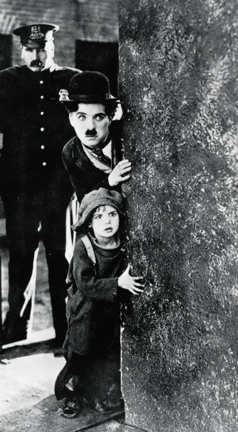  ??  ?? Charles Chaplin y el joven Jackie Coogan huyen de un policía en una escena de «El chico»