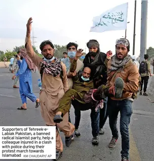  ?? KM CHAUDARY/ AP ?? Supporters of Tehreek-eLabiak Pakistan, a banned radical Islamist party, help a colleague injured in a clash with police during their protest march towards Islamabad