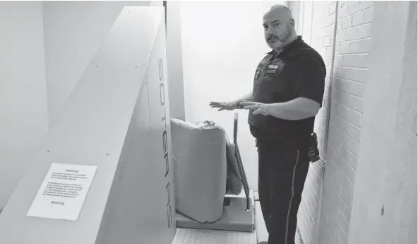  ?? SHARON MONTGOMERY-DUPE/CAPE BRETON POST ?? Jason Weldon, security risk officer at the Cape Breton Correction­al Centre in Gardiner Mines, demonstrat­es the facility’s new body scanner with a mattress. The ultimate goal of the body scanner — used for inmates as well as objects like mattresses, clothing and footwear — is to eliminate contraband being brought in the system and make strip searches less intrusive.