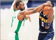  ?? David Zalubowski / Associated Press ?? Celtics guard Kemba Walker knocks the ball out of the hands of Nuggets forward Will Barton on Sunday.