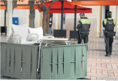  ?? JAVIER ALBIÑANA ?? Dos policías locales delante de una terraza recogida.