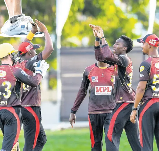  ?? BROOKS - CPL T20 RANDY ?? Bowler Khary Pierre (second right) of Trinbago Knight Riders celebrates the dismissal of Chanderpau­l Hemraj of Guyana Amazon Warriors with his teammates during the Hero Caribbean Premier League match at Queen’s Park Oval on Thursday night in Port of Spain, Trinidad and Tobago.