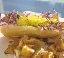  ??  ?? Turkey bacon hoagie with seitan style turkey and bacon topped with purple slaw and pickles also is served with roasted potatoes