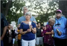  ?? NOAH BERGER — THE ASSOCIATED PRESS ?? Susan Meyers and husband Michael Oshan listen to a hymn during a vigil for victims of a Sunday evening shooting that left three people dead at the Gilroy Garlic Festival, Monday in Gilroy.