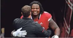  ?? /GETTY IMAGES ?? Kevin Wilkins, hugged by coach Chris Ash, appreciate­s his biological and adoptive moms.