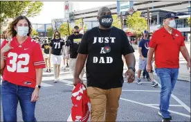  ?? STACEY WESCOTT / CHICAGO TRIBUNE ?? Ohio State football dad Randy Wade (middle) leads a group of players, parents and supporters toward Big Ten headquarte­rs Friday in Rosemont, Illinois. Parents of Big Ten football players, upset over the postponeme­nt of the season until spring, held a protest near the conference’s Chicago-area headquarte­rs.