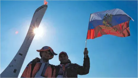  ?? FOTO: DPA ?? Glückliche Zeiten – bloß war vieles mehr Schein als Sein im Jahr 2014. Russische Winterspor­tfans vor dem Olympische­n Feuer in Sotschi.