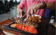  ?? (Henry Romero/Reuters) ?? A DINER EATS a ribeye steak – healthy or not?