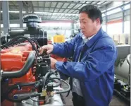  ??  ?? A technician at Shandong Supermaly Generating Equipment Co in the Weifang Hi-tech Industrial Developmen­t Zone checks power generators produced by the company.