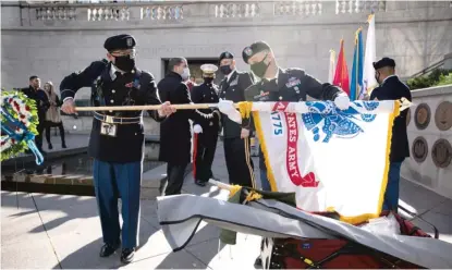  ??  ?? Color guard members unfurl a U. S. Army flag during Wednesday’s Veterans Day ceremony on the Chicago Riverwalk.