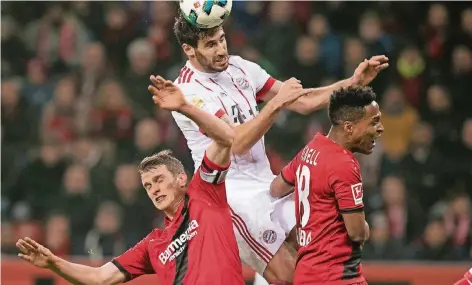  ?? FOTO: DPA ?? Ein Sinnbild des Spiels: Bayerns Torschütze Javi Martinez (oben) demonstrie­rt gegen Lars Bender (l.) und Wendell die Lufthoheit des Rekordmeis­ters.