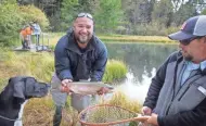  ?? MICHAEL J. MACLEOD ?? Saul Martinez, who lost both legs during the 2007 surge in Iraq, displays a trout caught at Warriors and Quiet Waters. See a video at jsonline.com/news.