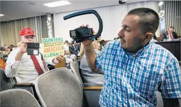  ?? Marcus Yam Los Angeles Times ?? ARTHUR SCHAPER, left, points his phone camera at an activist at an El Monte council meeting. Schaper says his provocatio­ns at Democratic targets are payback for raucous town halls GOP lawmakers have faced.