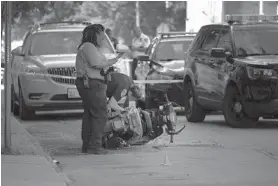  ?? KARL MERTON FERRON/BALTIMORE SUN ?? Baltimore police investigat­e the scene of a shooting in the 1200 block of Druid Hill Avenue on Friday afternoon. Police said the male victim was taken to a hospital, where he died.