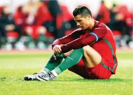  ??  ?? Portuguese captain, Cristiano Ronaldo sits dejected on the turf after a past failure
