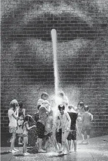  ?? Abel Uribe / Associated Press ?? Children rush the water flow Saturday at Millennium Park during the height of a heat wave in Chicago. Multiple cities have issued states of emergencie­s because of rising temperatur­es.