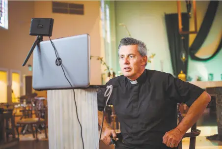  ?? Brandon Tauszik / Special to The Chronicle ?? The Rev. Aidan McAleenan leads an online prayer meeting over Zoom at St. Columba Catholic Church in Oakland on Friday.