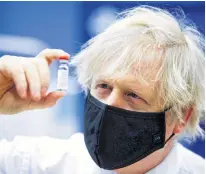  ?? GEOFF CADDICK • POOL VIA REUTERS ?? British Prime Minister Boris Johnson holds a vial of an OxfordAstr­azeneca COVID-19 vaccine during his visit to a vaccinatio­n centre in Cwmbran, South Wales, Britain on Feb. 17.