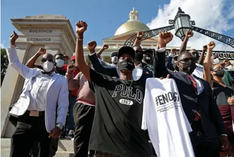  ?? Matt stoNe pHotos / BostoN HeraLd ?? FISTS UPRAISED: Brothers Building, a local group of Black Men in Boston, above and below, raise their fists during a rally against social injustices Black people face in front of the Massachuse­tts State House Friday.