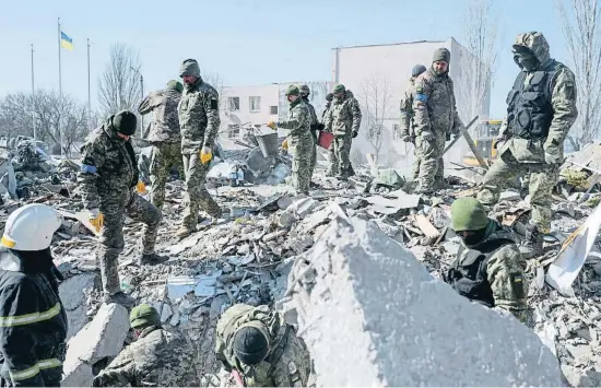  ?? BULENT KILIC / AFP ?? Soldats ucraïnesos busquen superviven­ts entre les restes de l’escola militar de Mikolàiv