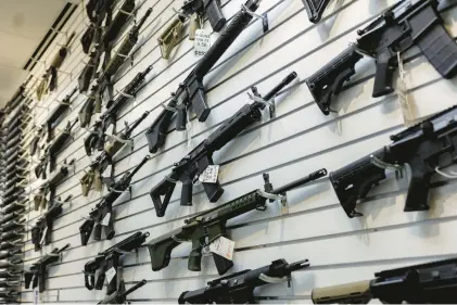  ?? ARMANDO L. SANCHEZ/CHICAGO TRIBUNE/TNS ?? A selection of AR-15-style rifles hangs on a wall at R-Guns store in Carpenters­ville, Illinois, a day after the state banned them. Washington last month became the 10th state to ban the rifles.