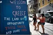  ?? (Photo AFP) ?? Graffiti contre la politique fiscale, dans le centre d’Athènes. Les chiffres sont bien meilleurs qu’en , mais le quotidien des Grecs reste très dur.
