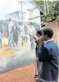  ?? DUMISANI DUBE ?? TUMO Makhetha and Nyama Makhuparet­jia from Fundulwazi Secondary School in Sebokeng, look at mural at Sharpevill­e Memorial site. |