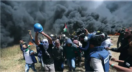  ?? (Ibraheem Abu Mustafa/Reuters) ?? PALESTINIA­NS EVACUATE Yaser Murtaja after he was shot during clashes with IDF troops on the southern Gaza border last Friday.