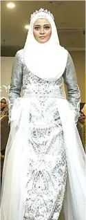  ?? GHOFUUR EKA/JAWA POS ?? PUTIH DAN PERAK: Seorang model mengenakan gaun pengantin karya Nungki Laksmi kemarin (27/7).